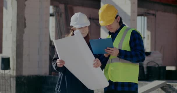 Supervisor holding blueprint while discussing with worker — 비디오