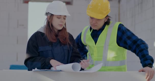 Female architect discussing over blueprint with male contractor — Video