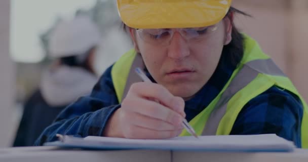 Confident male worker drawing while analyzing blueprint — Stock Video