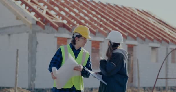 Confident female supervisor discussing over blueprint with worker — 비디오