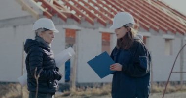 Kadın müteahhit tamamlanmamış alanda mühendis ile tartışıyor.