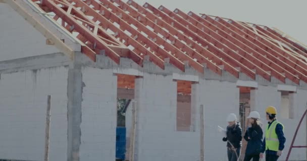 Женщина-архитектор обсуждает с коллегами по незавершенному зданию — стоковое видео