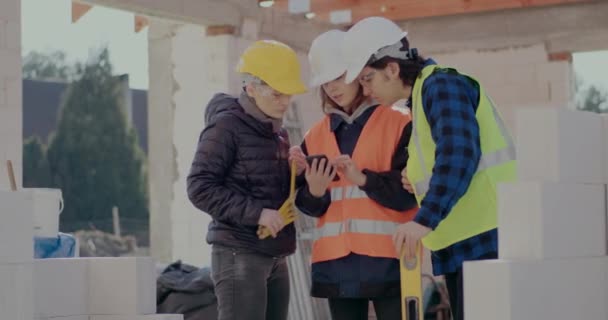 Unga medarbetare diskuterar via smartphone med ingenjör — Stockvideo