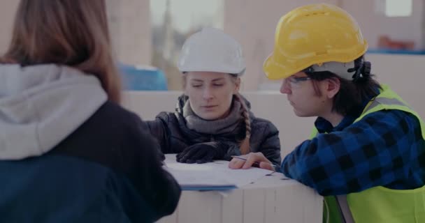 Engineer and contractor discussing over blueprint with architect — Video