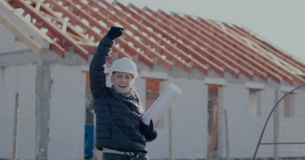 Счастливая женщина-инженер-строитель с чертежом, радующая себя — стоковое видео
