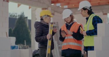 Genç iş arkadaşları akıllı telefondan müteahhitle tartışıyor.