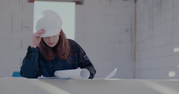 Magabiztos fiatal női építész, aki a helyszínen elemzi a tervrajzot — Stock videók