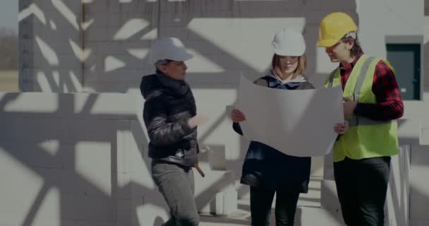 A mérnök megbeszéli a tervrajzot az építésszel és a kivitelezővel — Stock videók