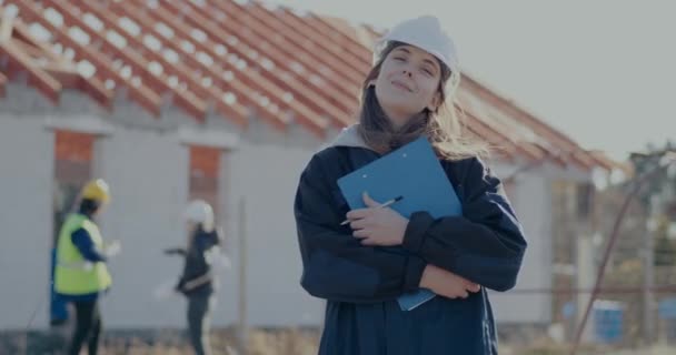 Smiling young female building contractor holding clipboard — Video