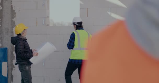 Trabalhador masculino medindo moldura de janela pelo arquiteto feminino — Vídeo de Stock