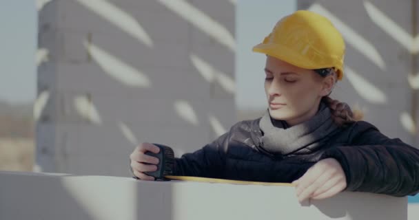 Confident female contractor measuring wall with tape — Stock Video