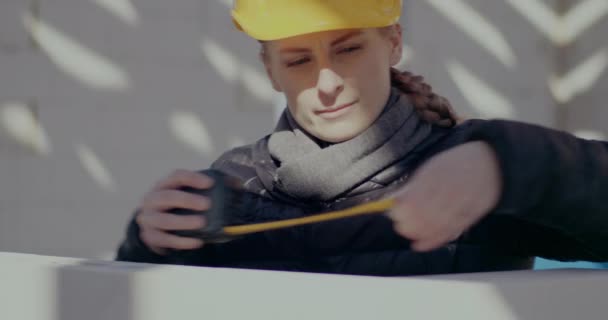 Confident female supervisor measuring wall with tape — Video Stock