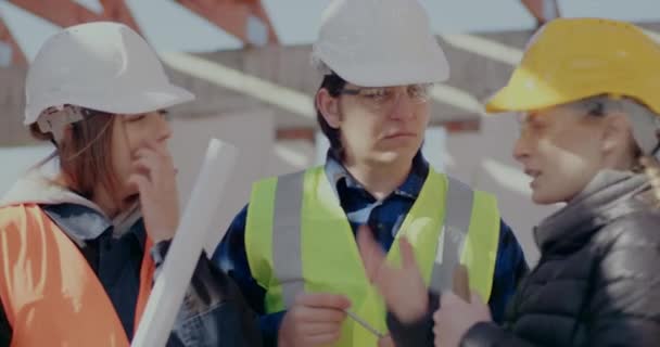 Wykonawca z pracownikami budowlanymi omawiającymi plan budowy — Wideo stockowe