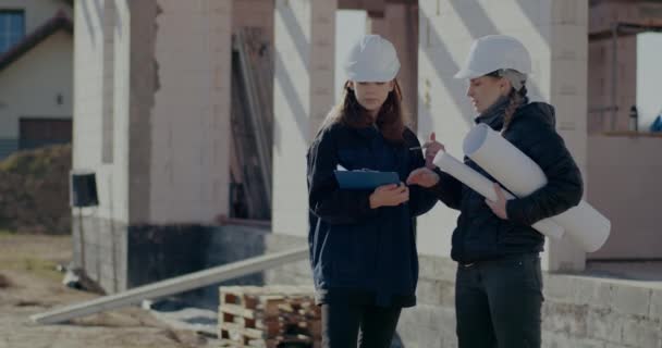 Female supervisor and contractor discussing over clipboard — стоковое видео