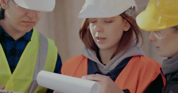 Female construction worker discussing with coworker and contractor — Stockvideo