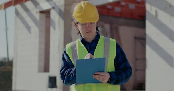 Young male contractor writing on clipboard — 비디오