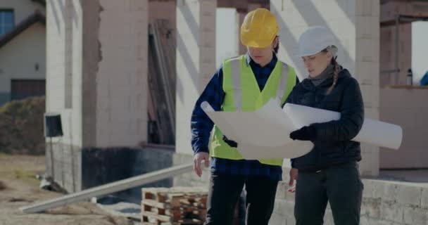 Kobieta nadzorująca instruowanie pracownika budowlanego na miejscu — Wideo stockowe