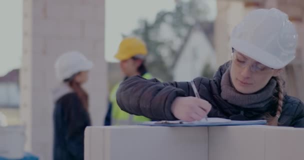 Jistá mladá žena stavební dodavatel kreslení nákres na místě — Stock video