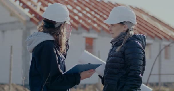 Female contractor discussing over incomplete building with engineer — стоковое видео