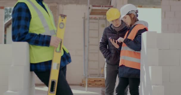 Работник мужского пола рядом с коллегами обсуждает на смартфоне — стоковое видео