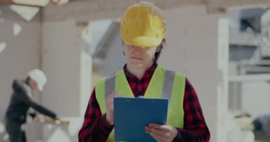 Kendine güvenen erkek müteahhit panoya yazı yazıyor.