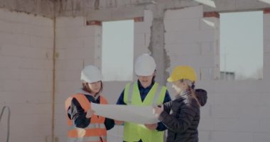 Müteahhit işçilerle planı analiz ediyor ve tartışıyor.