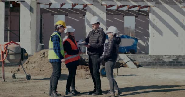 Ingenieur en architect in gesprek met bouwvakkers — Stockvideo