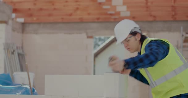 Male construction worker examining concrete wall with level — 비디오