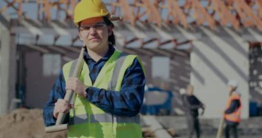 Omzunda kürek taşıyan kendinden emin bir erkek işçi.