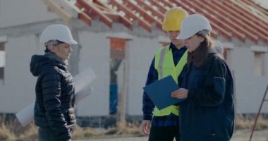 Müteahhit ve işçi hayal kırıklığına uğramış inşaat mühendisine pano gösteriyor