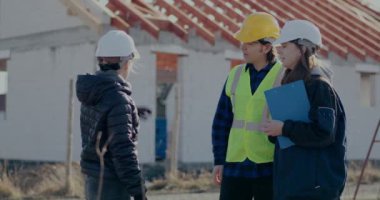 Kadın mimar müteahhit ve işçiyi selamlıyor.