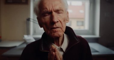 Huzurevinde dua eden yaşlı adam.