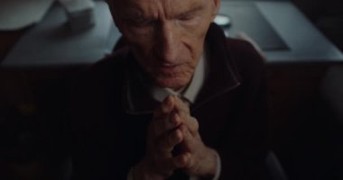 Huzurevinde dua eden yaşlı adam.