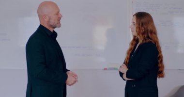 Businesswoman talking with Businessman, discussing project, shaking hands after successful meeting.