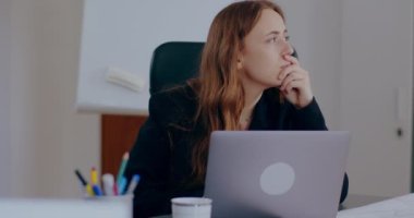 medium shot of Tensed Businesswoman Working on Laptop in Office. Stressed Businesswoman In Office working on a project, writing e-mail.