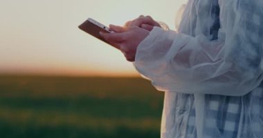 Medium shot of Agriculture Scientist Researcher using Digital Tablet Outdoors. Female Scientist using digital tablet computer. Farmer using Tablet.