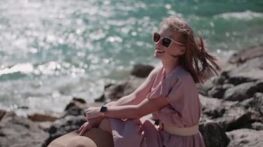 Göl kıyısında tatillerde gevşeyen pozitif gülümseyen bir kadın.