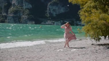 Göl kıyısında tatillerde gevşeyen pozitif gülümseyen bir kadın.