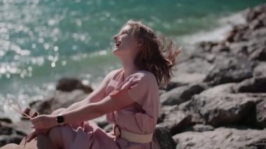 Göl kıyısında tatillerde gevşeyen pozitif gülümseyen bir kadın.