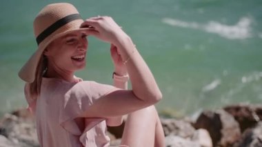 Göl kıyısında tatillerde gevşeyen pozitif gülümseyen bir kadın.