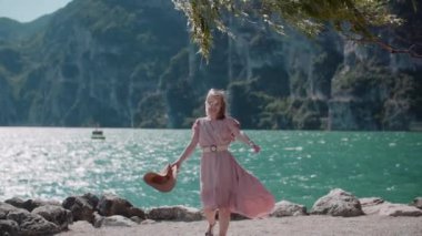 Göl kıyısında tatillerde gevşeyen pozitif gülümseyen bir kadın.