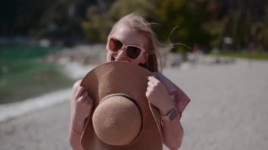 Göl kıyısında tatillerde gevşeyen pozitif gülümseyen bir kadın.