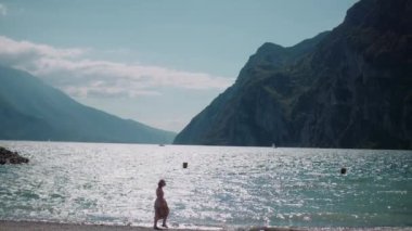 Göl kıyısında tatillerde gevşeyen pozitif gülümseyen bir kadın.