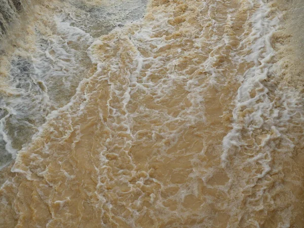 The brown water was flowing fast and was splashing violently, Flood in rainy season, Thailand