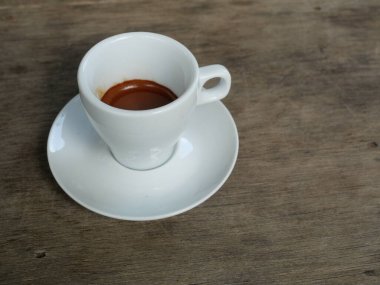 Espresso Coffee  in white cup on brown wooden table , Hot drink on ceramic plate