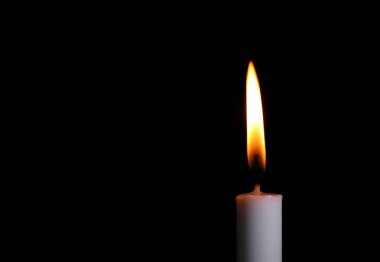 Sarı mum ateşiyle beyaz bir mum yak. Geceleri yakın çekim yapmak için ışık sağlıyor. Siyah arkaplanda izole edilmiş