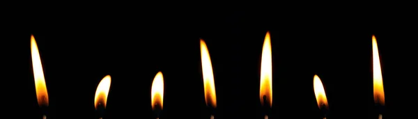 蜡烛的火焰在夜间近距离燃烧 黄色的光隔离在黑色的背景上 — 图库照片