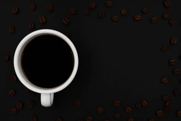 顶部的黑色热咖啡与白色陶瓷杯 烤咖啡豆平铺在黑暗的背景上 带有用于添加文本的复制空间 — 图库照片