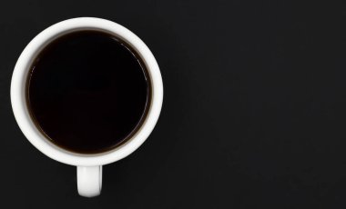 Beyaz seramik fincanlı sade sıcak kahvenin üst görüntüsü. Siyah bir arka planda izole edilmiş. Metin eklemek için kopyalama alanı ile