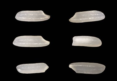 Üst manzara, yakın çekim makro çekim. Pişmemiş uzun kahverengi pirinç taneleri, dümdüz yatıyor. Siyah arkaplanda izole.